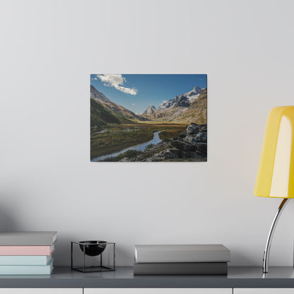 Mounted landscape photo of a river winding through a mountain valley with rocky peaks and blue sky.
