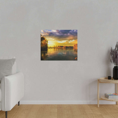 Small square painting of a sunset river scene with trees along the riverbank, mounted on a light gray wall.
