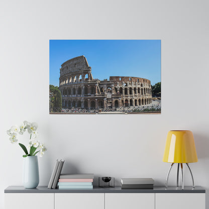 Exterior view of the Colosseum in Rome, showing its stone arches and surrounding fencing against a clear blue sky.