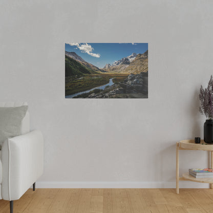 Framed landscape poster of a mountain valley with a winding river, rocky foreground, and clear blue sky.