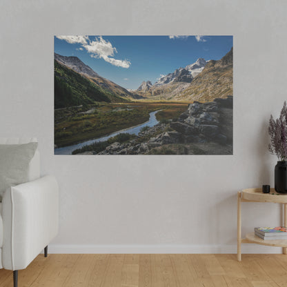 Landscape poster of a mountain valley with a winding river, rocky foreground, and snow-capped peaks under a blue sky.