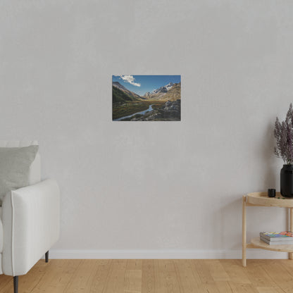 Small framed landscape photo of a river winding through a mountainous valley under a blue sky.