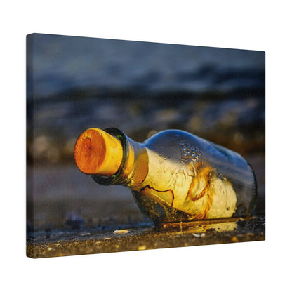 A glass bottle with a yellow label and orange cork lies on a wet, pebbled ground.