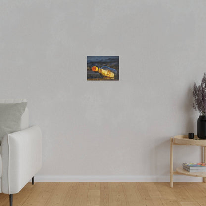 Small rectangular painting of a yellow-brown bottle lying on a shore, hung on a light gray living room wall.