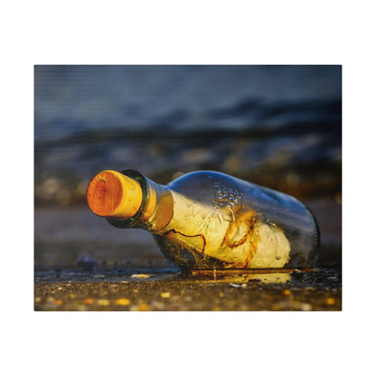 A clear glass bottle with an orange cap lies on a wet sandy beach, with water droplets on its surface.