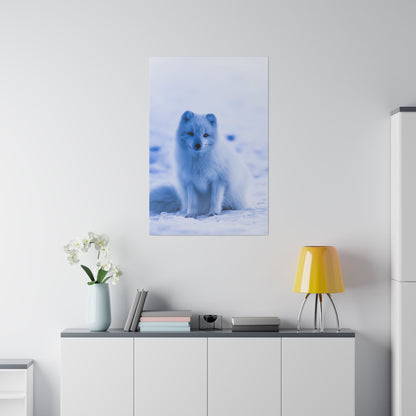 Poster of a white Arctic fox sitting in snowy blue-toned surroundings, hung on a white wall above a cabinet.