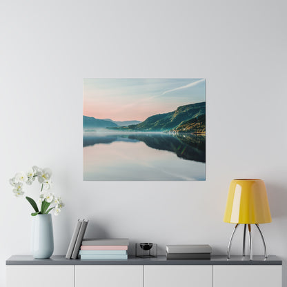 Square wall art of a calm lake, mountains, and pastel sky with reflection; hung above a gray cabinet with white orchids and a yellow lamp.