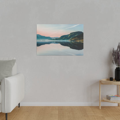 Landscape wall art depicting a calm lake with mountains and a pink sunset, hung on a light gray wall.