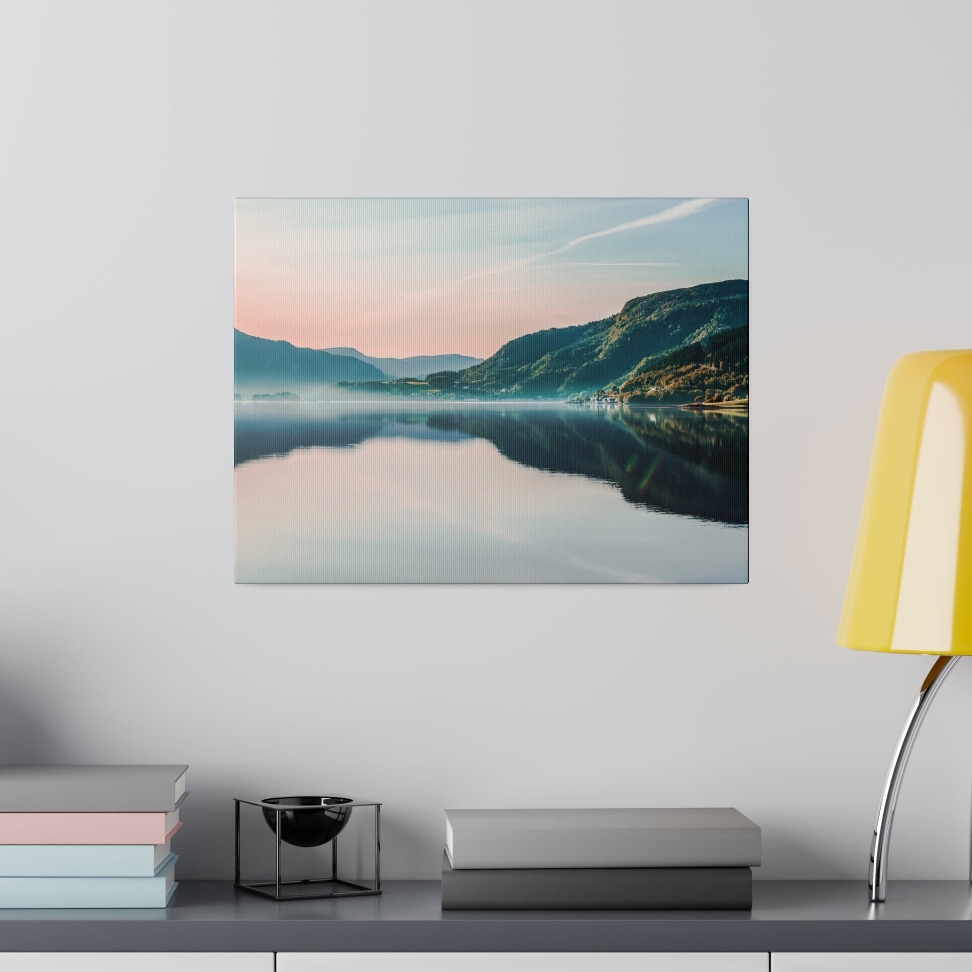 Landscape wall art showing a calm lake with reflections, pink-blue sky and green mountains in the distance.