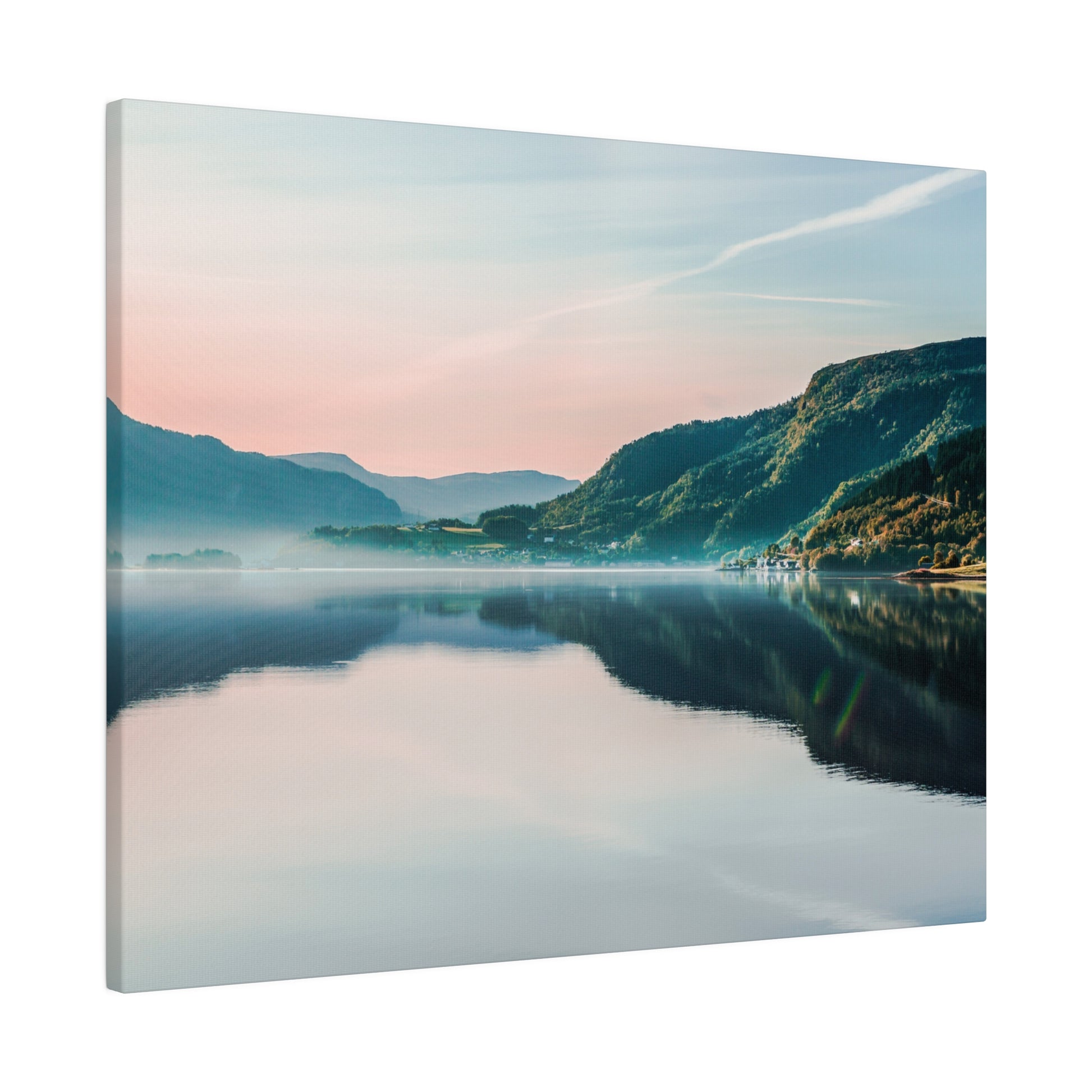 Landscape of a calm lake reflecting green mountains and a pastel sky at dawn.