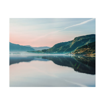 A tranquil mountain lake at dawn with calm water reflecting a pastel sky and tree-covered hills.