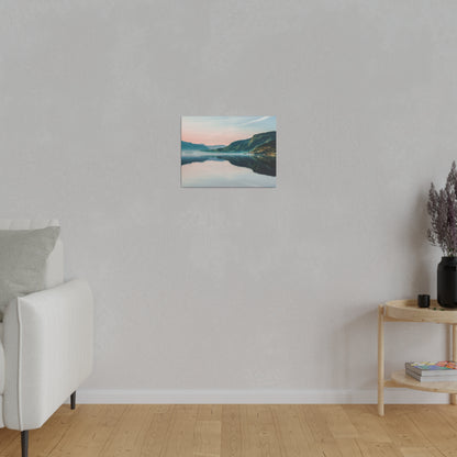 Small landscape canvas print of a lake and mountains hanging on a light gray living room wall.
