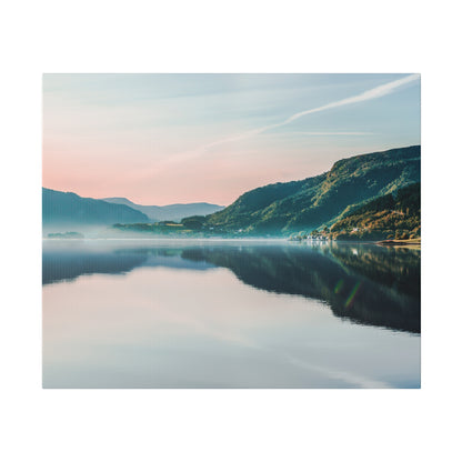 Calm lake with a mirrored reflection of green hills and pastel sky, mountains in the distance.