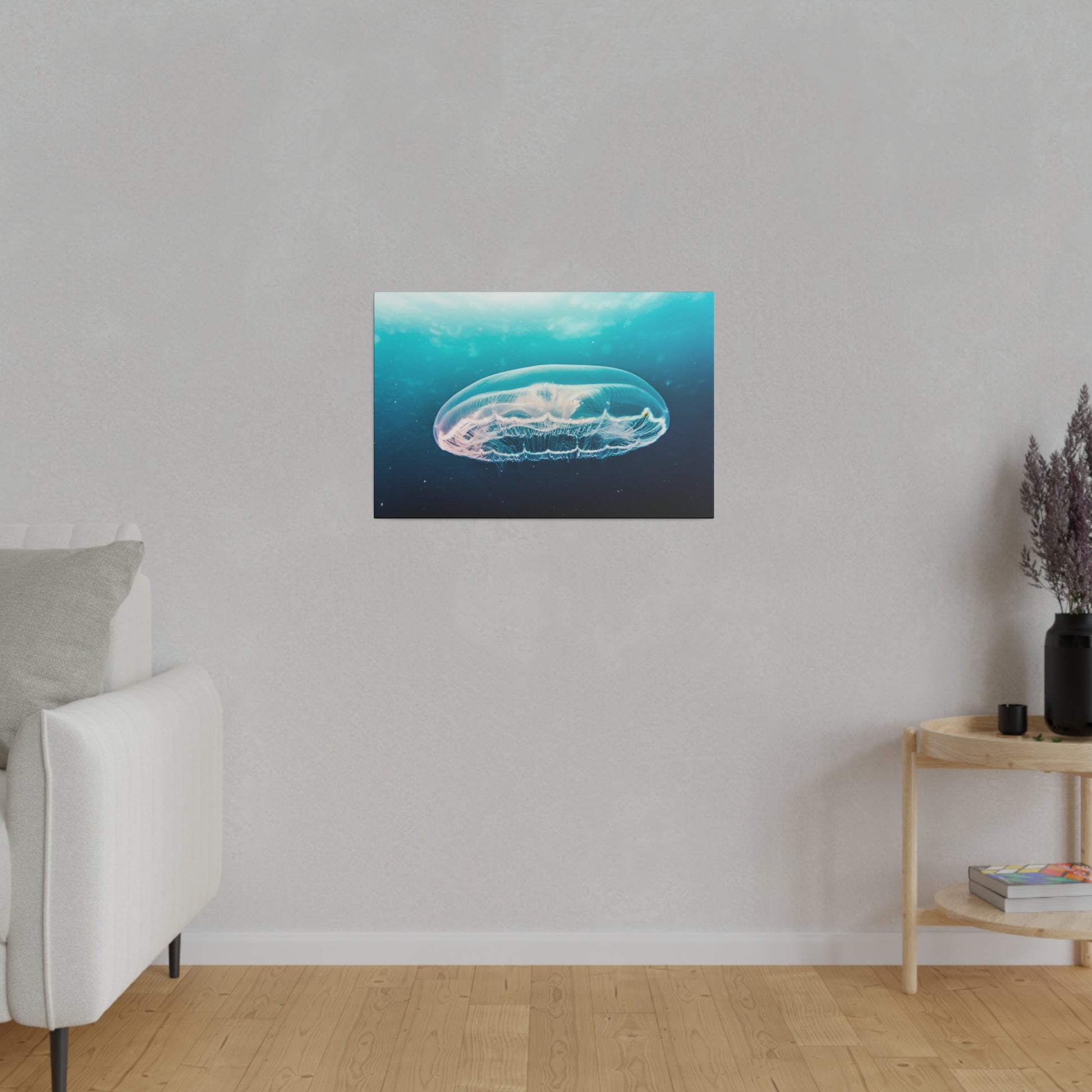 Rectangular wall art depicting a translucent jellyfish swimming in blue water, mounted on a light gray wall above a wooden floor.