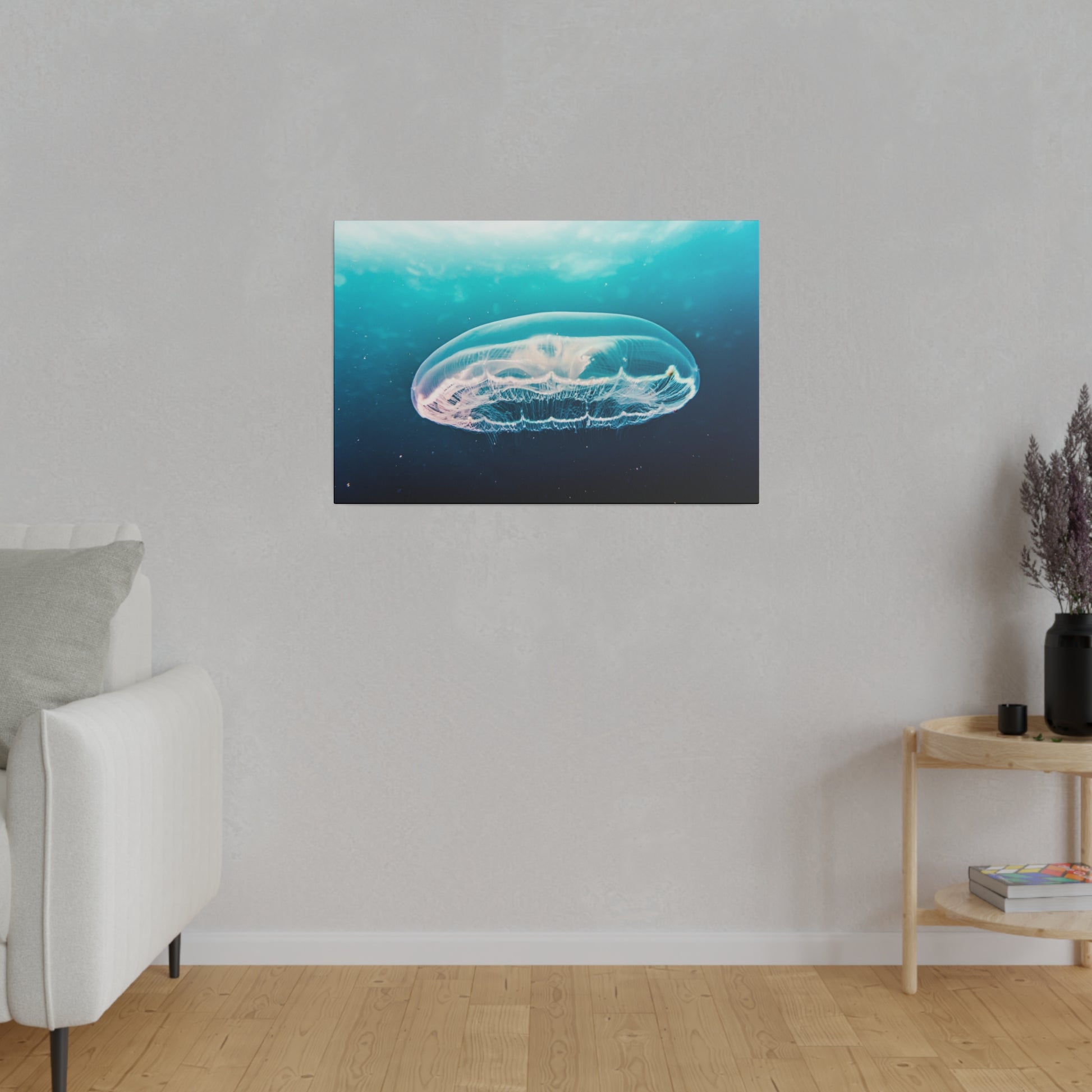 Rectangular wall art displaying a translucent jellyfish swimming in blue ocean, hung on a light gray wall.