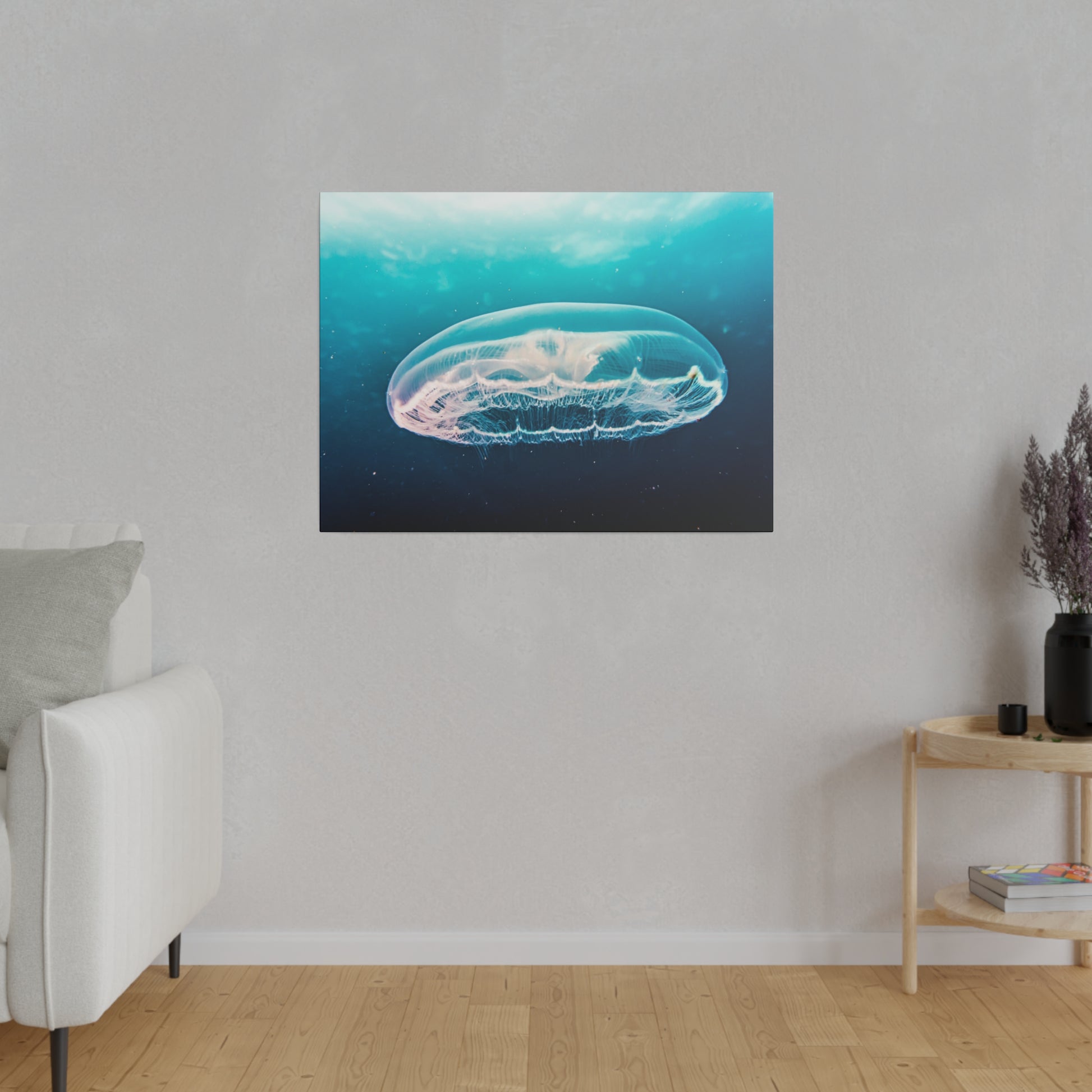 Rectangular wall art showing a translucent jellyfish in a blue ocean, mounted on a light gray wall.