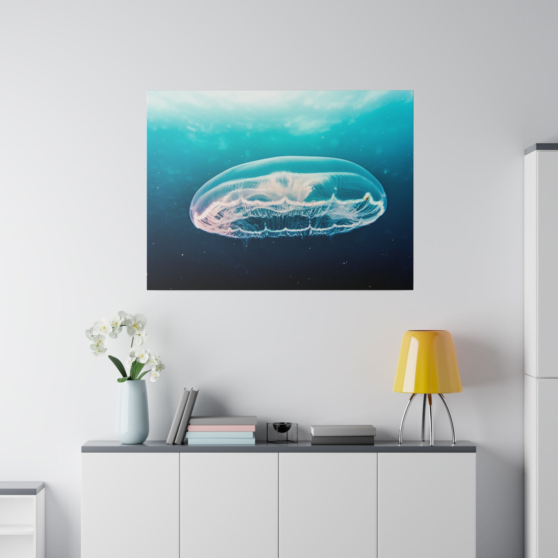 Large wall art depicting a translucent jellyfish floating in blue ocean water above a white cabinet.