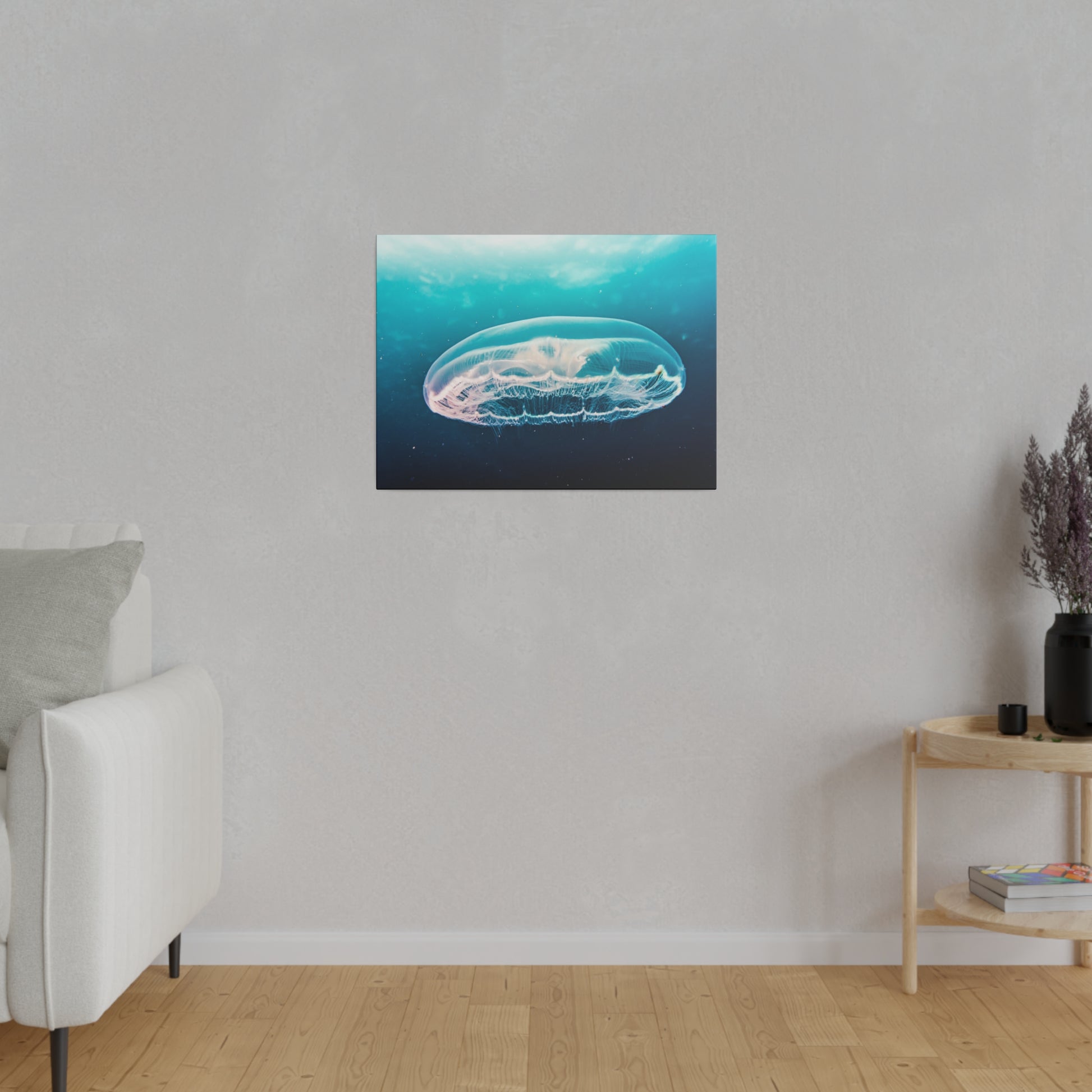 Framed blue underwater jellyfish print hangs on a light gray wall above a wooden floor.