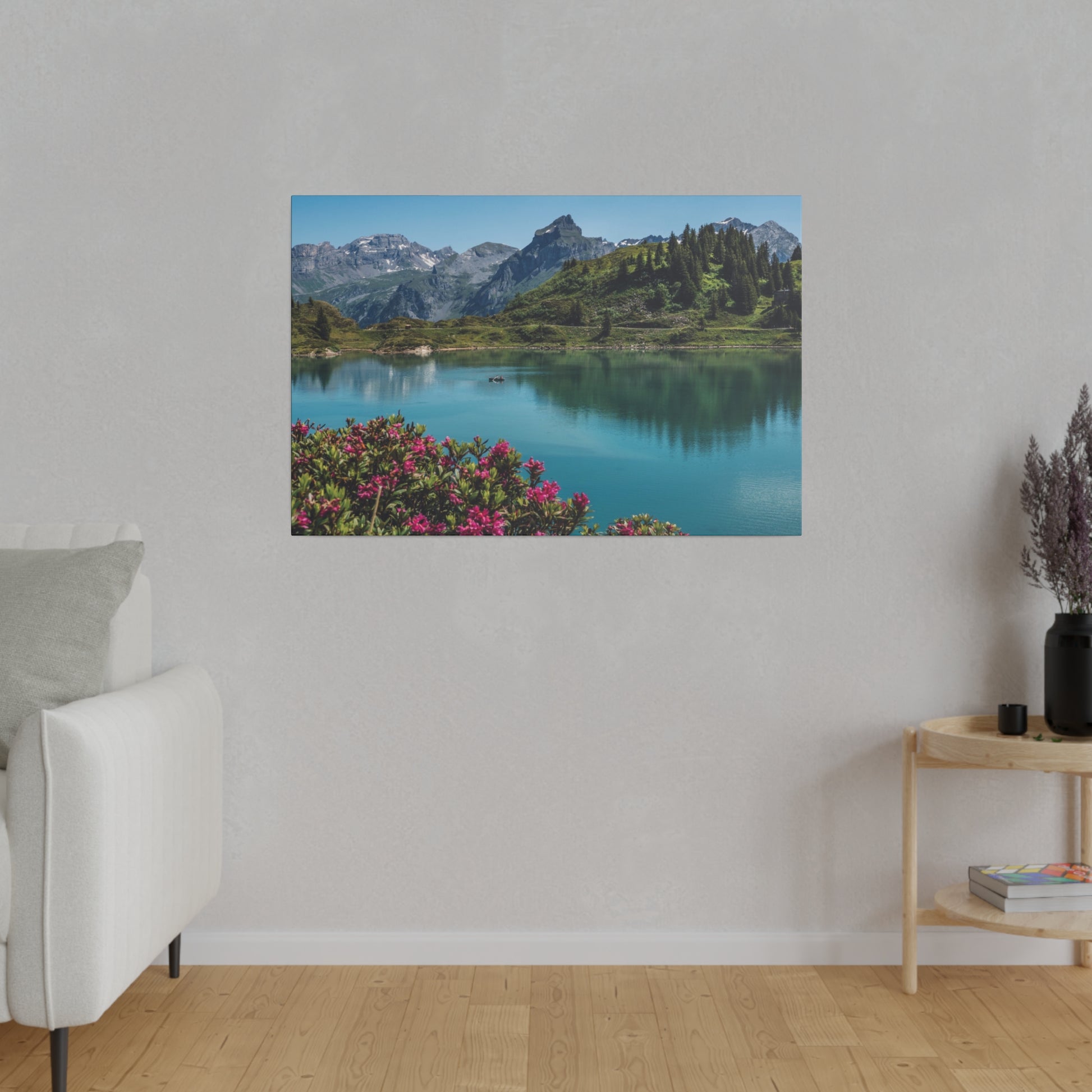 Landscape wall art showing a blue alpine lake with pink flowers in the foreground and green mountains in the distance.