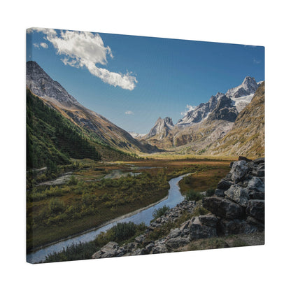 Valley with a winding river, rocky foreground, green slopes, and snow-capped mountains beneath a blue sky.
