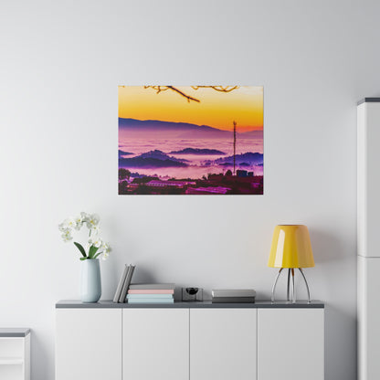 Colorful landscape photograph of a sunrise over misty hills, hung above a white cabinet in a bright room.