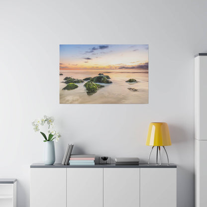 A white cabinet with a yellow lamp on the right and a framed sunset beach photo above it.