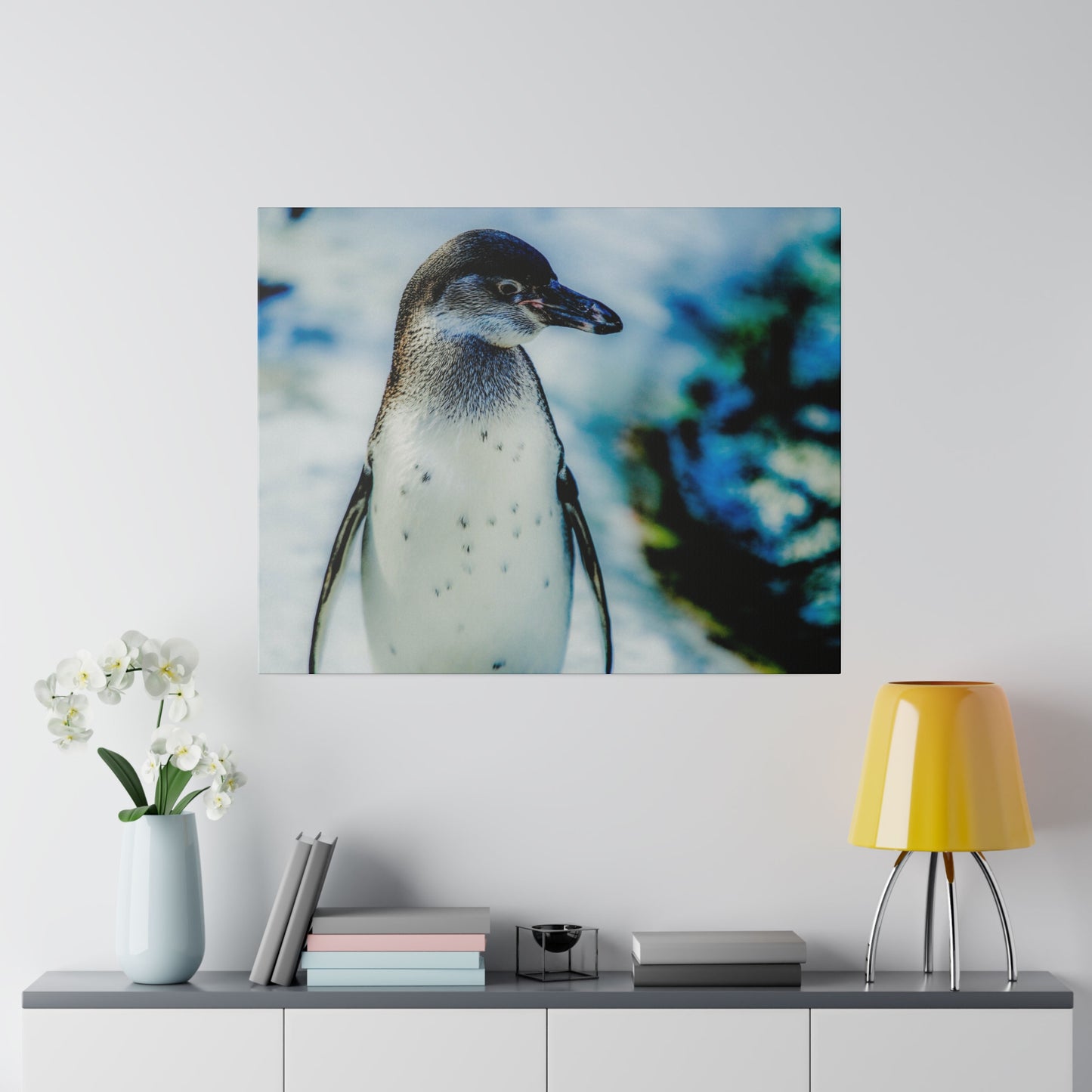 A single penguin standing in the snow, with a blurred blue and white background. The penguin is captured in a close-up shot, showcasing its natural beauty.