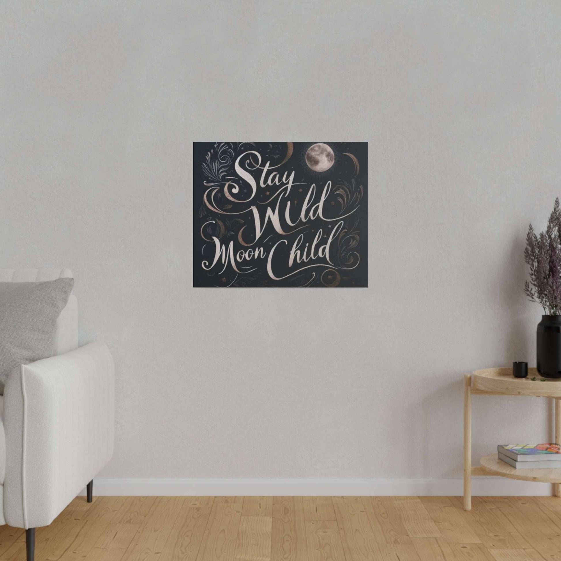 Square dark canvas print with white cursive text “Stay Wild Moon Child” and decorative swirls and a small moon.