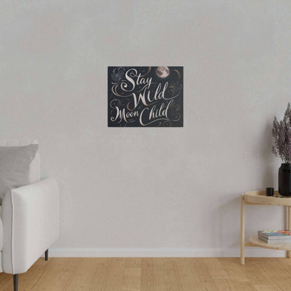 Square canvas print on a light wall displaying the phrase “Stay Wild Moon Child” in white script with moon motifs.