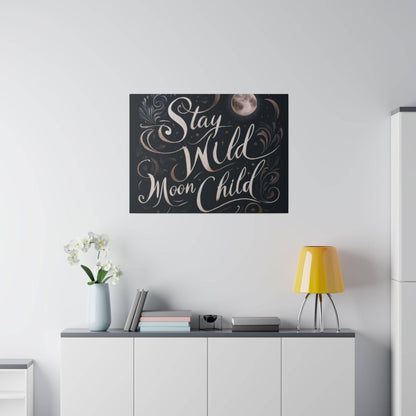 Wall-mounted black artwork with decorative swirls and the phrase “Stay Wild Moon Child” above a white cabinet.