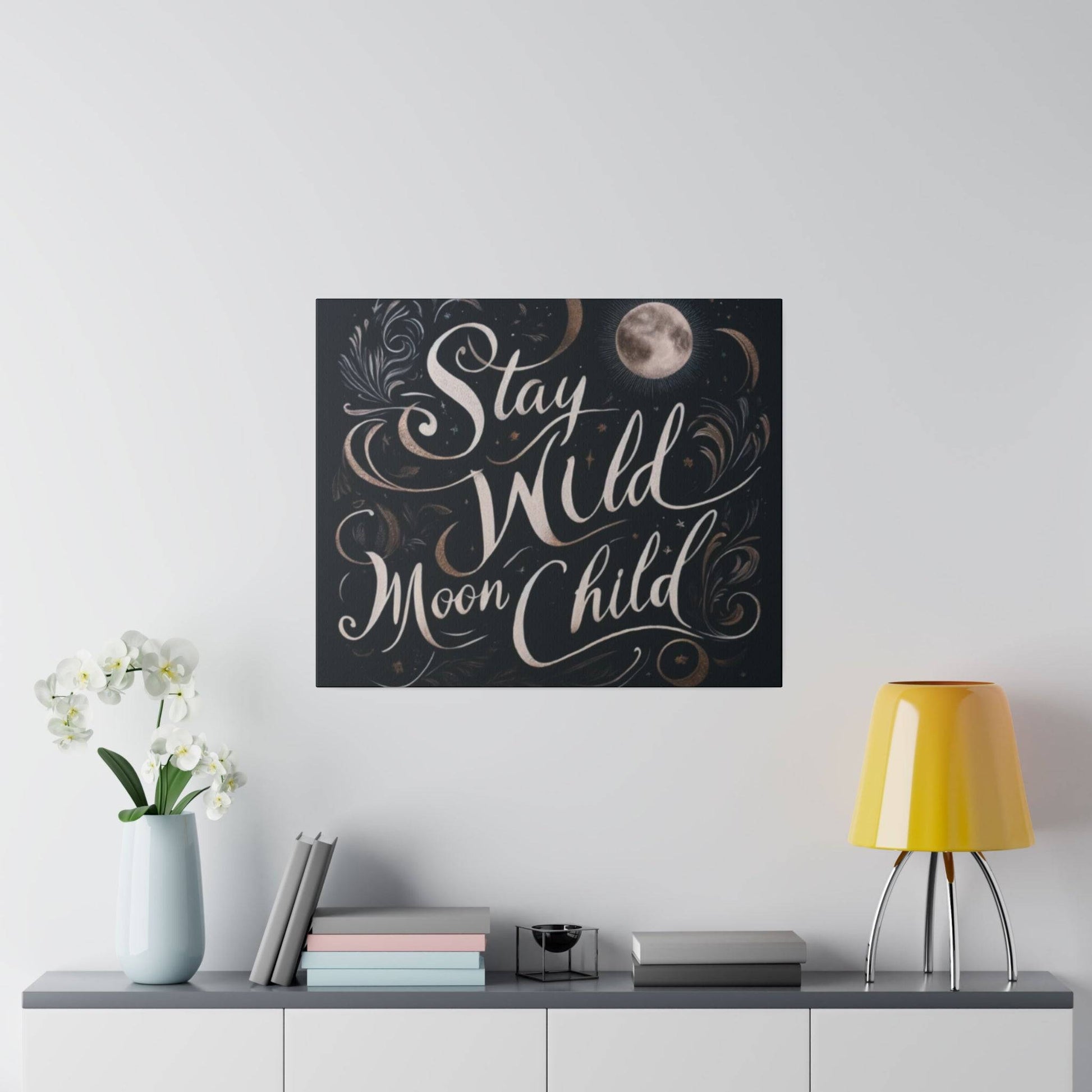 Square dark wall art with beige cursive text “Stay Wild Moon Child” and a moon motif.