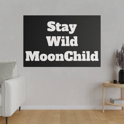 White sofa in a light living room with a large black rectangular wall art reading "Stay Wild MoonChild".