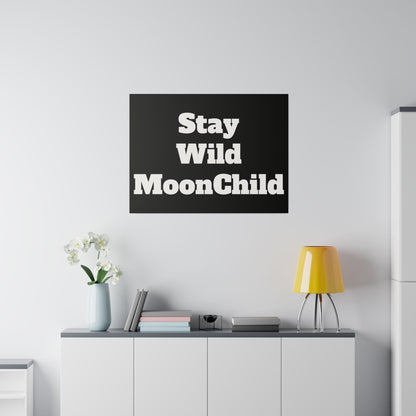 Black square wall art with bold white text "Stay Wild MoonChild" hung above a white sideboard in a minimalist living room.