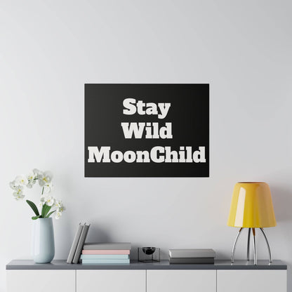 Black square poster with large white bold text reading 'Stay Wild MoonChild' hung on a light wall above a cabinet.