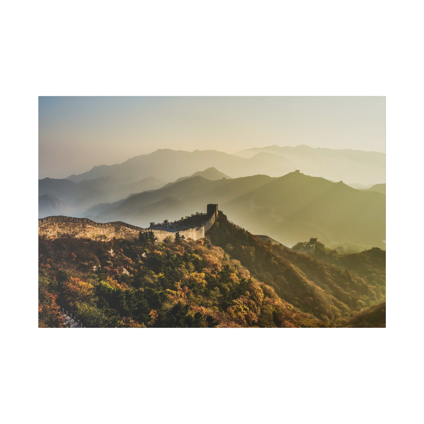 Sunrise over the Great Wall of China, casting a warm glow on the ancient stones and surrounding scenery.