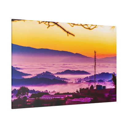 Colorful sunrise over a misty valley with purple hills, silhouetted village rooftops, and a tall antenna on a hill.