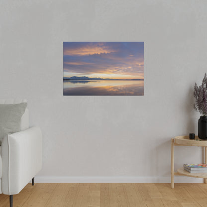 Framed canvas of a calm lake at sunset with orange and blue sky, mountains reflected on the water.