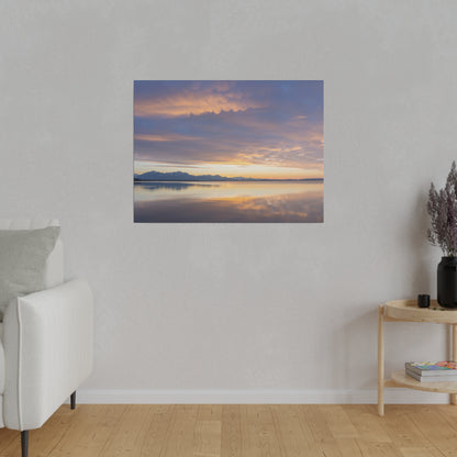 Rectangular wall art of a sunset over a calm lake with distant mountains, orange and purple sky reflecting on the water.