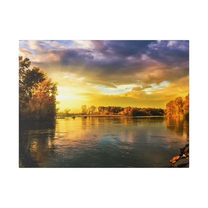 River scene at sunset with golden light reflecting on calm water and trees lining both banks.