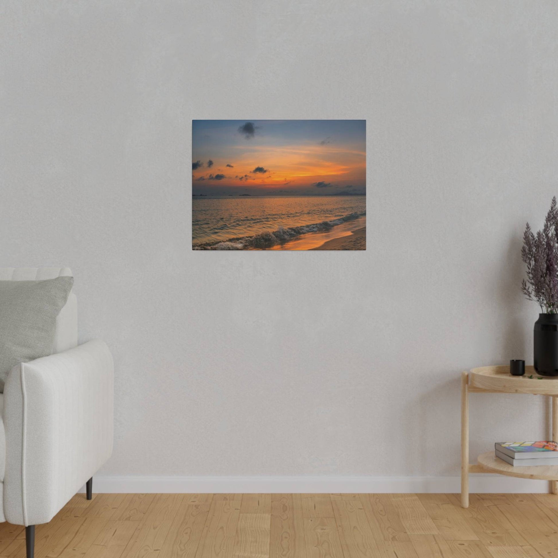White upholstered sofa on a light gray wall with a sunset beach painting hung centered above.