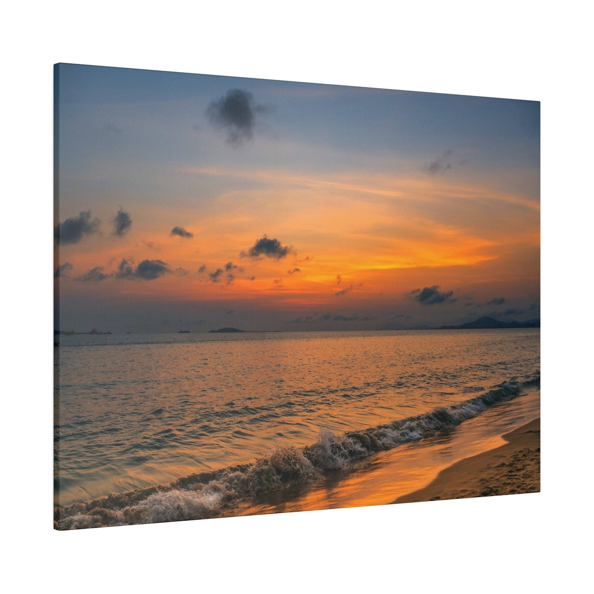 Calm ocean at sunset with orange and pink sky, gentle waves washing onto a sandy shore.