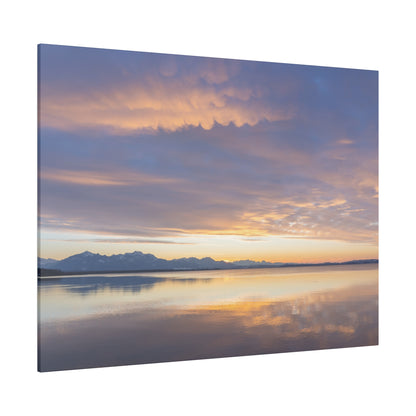 Canvas print showing a calm lake at sunset with orange and purple sky and distant snow-capped mountains.