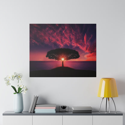 Square photo of a lone tree on a small hill silhouetted against a red-orange sunset over the ocean.