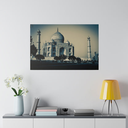 Blue-toned photograph of the Taj Mahal with the central dome, two minarets, and trees in the foreground.