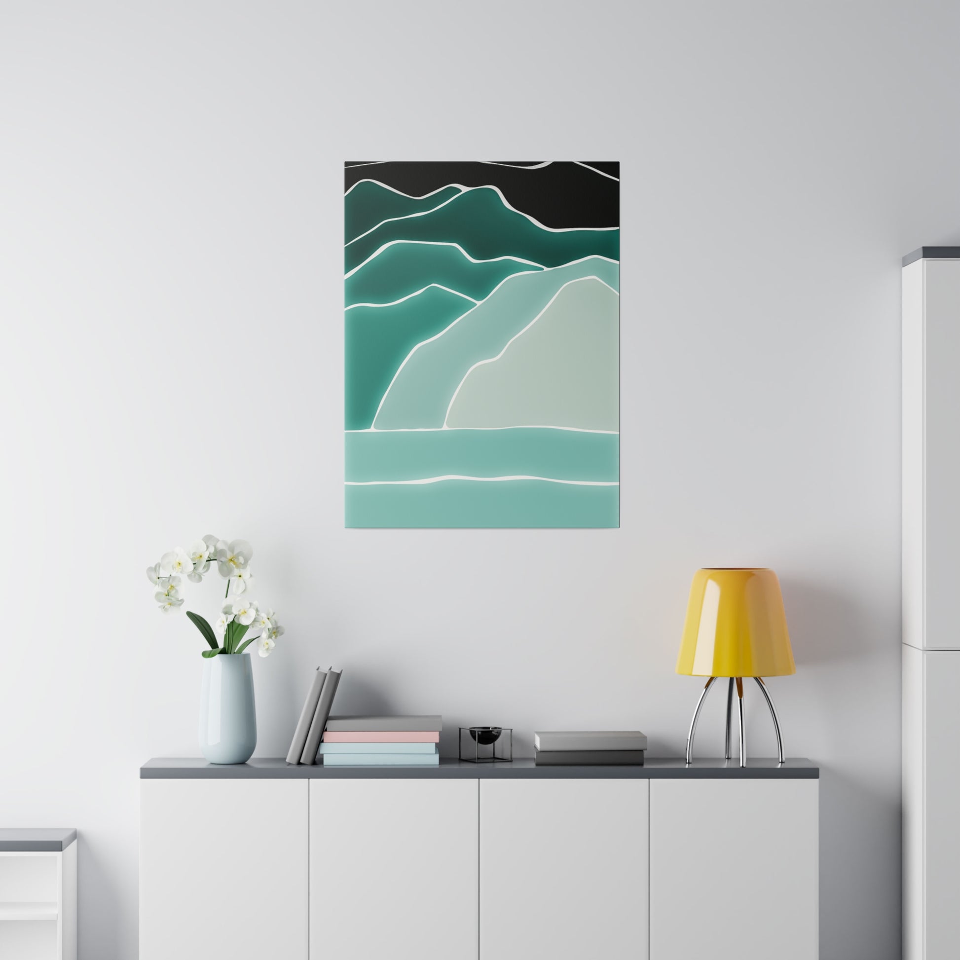 Abstract teal landscape wall art with layered, wavy mountains in teal and mint on a black background, mounted above a white cabinet.