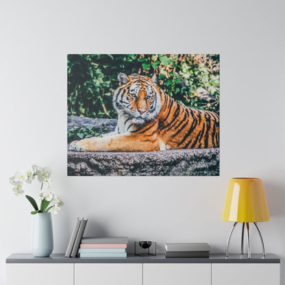 Tiger wall art on canvas: an orange and black striped tiger resting on a stone ledge with green foliage in the background.