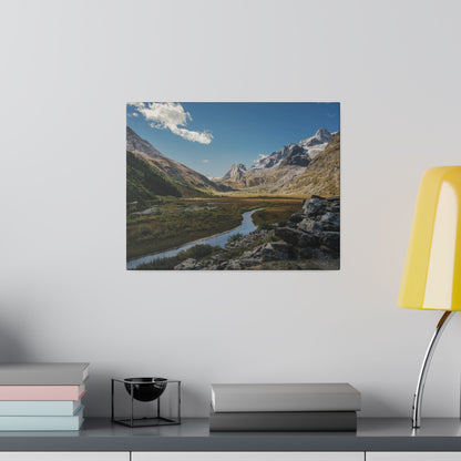 Square canvas print of a mountain valley with a winding river, green fields, and rocky foreground under a blue sky.