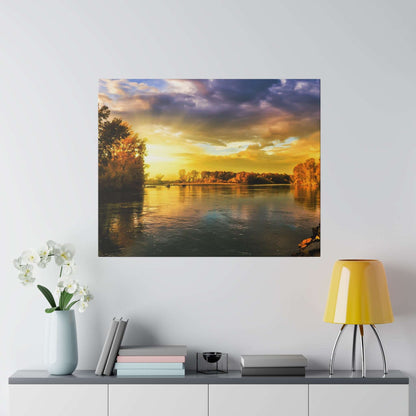 Colorful sunset over a calm river with trees along the banks, reflecting golden light on the water.