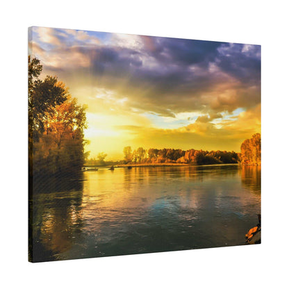 Calm river at sunset with golden sky, reflecting yellow and orange clouds and trees along the banks.