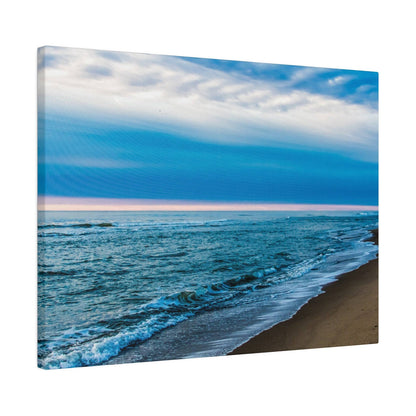 Canvas wall art print of a blue ocean shoreline with gentle waves along a sandy beach under a cloudy sky.
